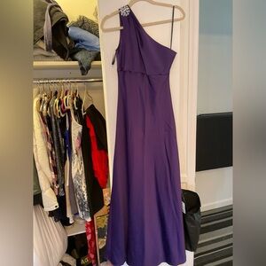 Purple one shoulder gown with stone brooch